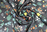 Swirled swatch Strawberry Fields collection floral printed fabric in pressed floral (small multi-coloured floral bunches on black)