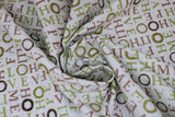 Swirled swatch Home Love fabric (white fabric with multi-directional words allover in beige and green saying "HOME" "HOPE" "LOVE" etc., some circular leafy wreaths in green and brown)
