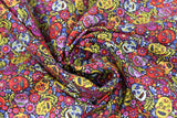 Swirled swatch sugar skulls fabric (small busy tossed decorative sugar skulls and paisley like swirls and floral allover toss in red, purple, yellow, cream colourway)