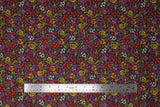 Flat swatch sugar skulls fabric (small busy tossed decorative sugar skulls and paisley like swirls and floral allover toss in red, purple, yellow, cream colourway)