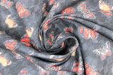 Swirled swatch fabric tossed butterflies black (black fabric with small and medium tossed butterflies in black, red, and yellow shades)