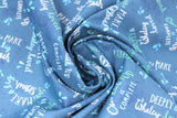 Swirled swatch whale themed fabric in Big Splash Dark (splash and whale themed text collage on dark blue)