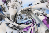 Swirled swatch big floral watercolour fabric (white with large tossed floral in grey, light blue, and purple with watercolour effect)
