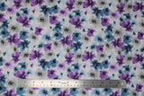 Flat swatch small floral watercolour fabric (white with small tossed floral in grey, blue, and purple with watercolour effect)