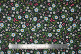 Flat swatch Flowers & Snakes fabric (charcoal grey fabric with tossed floral in white and pink and greenery allover with coloured snakes and lady bugs)