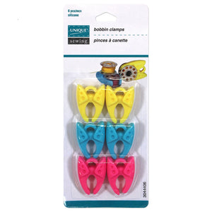 Package of 6 plastic bobbin clamps (2 yellow, 2 blue, 2 pink) on white background