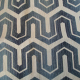 Woven upholstery fabric in a navy and cream geometric print.  Cream shallow chevrons with posts extending out from each point, over navy.  A thinner cream line traces the space between each offset row of chevrons
