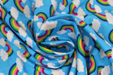 Swirled swatch Blue Rainbow fabric (medium blue fabric with rainbow arches with white clouds on both ends allover)