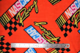 Flat swatch Nascar Retro Racing Flags fabric (red fabric with large loosely tossed nascar text logos with vintage rainbow style flag)