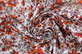 Swirled swatch playtime print in rust flowers (white fabric with busy orange/green floral drawings allover)