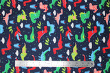 Flat swatch dinosaurs fabric (dark navy fabric with simple cartoon tossed dinosaurs in red, blue, green, grey shades, tossed clouds, polka dots, trees and leaves)