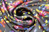 Swirled swatch Ophelia Satin Print (black fabric with tossed brightly multicoloured floral allover with short stems and leaves)