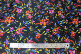 Flat swatch Ophelia Satin Print (black fabric with tossed brightly multicoloured floral allover with short stems and leaves)