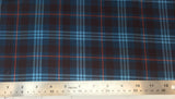 Flat swatch highland tartan printed fabric in blue (dark blue fabric with light blue, red, and black plaid lines)