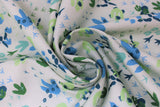 Swirled swatch white fabric (white fabric with tossed dinosaur tracks/foot prints allover in various sizes and styles all in green and blue shades)