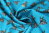 Swirled swatch Coco's Safari - monkey fabric (aqua blue fabric with tossed cartoon style monkeys in brown shades with yellow hats)