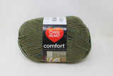 A ball of Red Heart Comfort yarn in shade moss fleck (pale medium green with bright green and blue flecks)