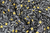 Swirled swatch assorted bee printed fabric in busy bees black (black fabric with tossed small yellow flower heads and white tiny bees and leaves allover)