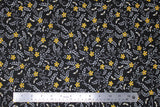 Flat swatch assorted bee printed fabric in busy bees black (black fabric with tossed small yellow flower heads and white tiny bees and leaves allover)