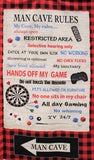 "Man Cave Rules" panel (24" x 44") Red/black buffalo check background with white piece of paper with rules "Junk food allowed" etc. text and man cave emblems remote, dice, etc.