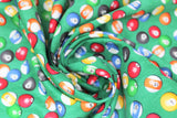 Swirled swatch man cave themed fabric in pool balls green (medium green fabric with tossed pool balls)