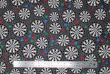 Flat swatch man cave themed fabric in darts grey (dark grey fabric with tossed dart boards assorted sizes with red/blue/green darts)