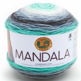 A cake of Lion Brand Mandala yarn in colourway genie (white, baby blue, aqua, pale blue, dark grey)