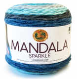 A cake of Lion Brand Mandala Sparkle yarn on white background in colourway aquarius (light grey, dark grey, aqua, medium blues with metallic sparkles throughout)