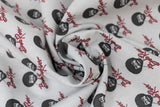 Swirled swatch Bob Ross collection fabric in Bob Ross print (light grey fabric with tiled black and white Bob Ross heads with red signatures beneath)