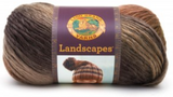 A ball of Lion Brand Landscapes yarn on white background in colourway sand dune (tan, brown, medium brown)