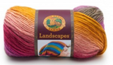 A ball of Lion Brand Landscapes yarn on white background in colourway coral reef (baby pink, coral, fuchsia, yellow/gold, purple, grey)