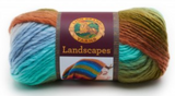 A ball of Lion Brand Landscapes yarn on white background in colourway meadow (baby blue, aqua, olive green, pale burnt orange)