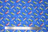 Flat swatch magical themed printed fabric in print dragons (medium blue fabric with tiny white cloud puffs and cartoon dragons in green/pink/blue/purple colours)