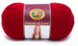 A ball of Lion Brand Pound of Love yarn on white background in shade cherry (bright red)