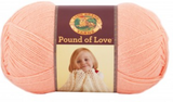 A ball of Lion Brand Pound of Love yarn on white background in shade creamsicle (pale orange/pink)