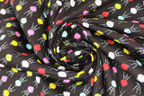 Swirled swatch BBQ fabric (black fabric with tiled tiny circular 3-leg BBQs in yellow, white, pink, red, blue)
