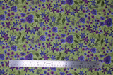 Flat swatch celery fabric (green fabric with tossed purple floral heads in various styles with dark green stems and leaves tossed allover)