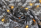 Swirled swatch Decorative Webs fabric (black fabric with ornate/victorian style decor and skulls in background with thick bubbled stripes outlined in swirly leaves with grey spider webs and orange spiders)