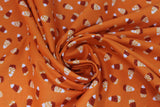 Swirled swatch Candy Corn Orange fabric (deep orange fabric with tossed candy corn with ornate/decorative pattern in orange sections)
