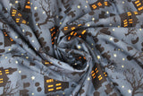 Swirled swatch Haunted House fabric (grey misty sky looking fabric with crooked lines of halloween silhouette emblems: haunted houses with glowing orange windows, grave stones, trees, pumpkins, birds, and tossed white stars)