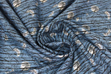 Swirled swatch Trees fabric (medium faded blue fabric with long thin black tree branches allover in long stripes with tossed white glowing moons in various phases)