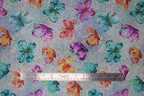 Flat swatch butterflies fabric (light teal marbled look fabric with pink, red and orange cross hatch look marks allover and large tossed watercolour floral look butterflies in blue, purple, orange, teal, red)
