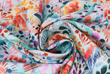 Swirled swatch blue fabric (light blue fabric with large tossed floral heads, stems and dots in watercolour look in blue, red, purple, orange, yellow colourway)