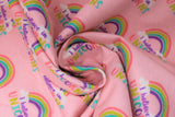 Swirled swatch I believe pink fabric (baby pink fabric with repeated rainbow arches with white clouds on either end and "I believe in" text in purple "unicorns" text in rainbow colours)