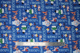 Flat swatch navy fabric (blue fabric with white character name texts allover horizontal and vertical "Rudolph" "Clarice" etc. with tossed full colour movie characters and snowflakes)