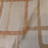 Woven jacquard upholstery fabric in beige with the outlines of overlapping rounded rectangles in tan and gold.