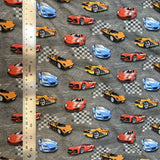 Square swatch knit material in street race grey (yellow, red, and blue race cars with checkered flags on grey)
