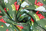 Swirled swatch child small packages fabric (dark green fabric with green the child character in and around large red and blue christmas presents, tossed green and red hollies, white "Seasons Greetings" and "The best things come in small packages" text)
