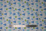 Flat swatch child snow day fabric (white fabric with lines of assorted blue trees and black tree outlines, green the child tossed making snow angels and making a snowman, zooming around in a space pod, tossed allover)