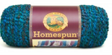 A ball of Lion Brand Homespun in a boucle texture and colourway Lagoon (teal and royal blue with maroon)
